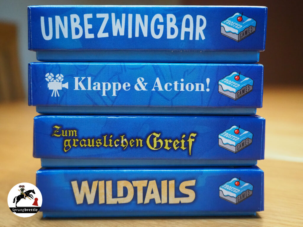 Die vier Minis von Frosted Games sind aufeinandergestapelt. Die Farbe der Schachteln ist blau. Jede Schachtel verfügt über den Titel des Spiels von weißer bis gelber Schriftfarbe.